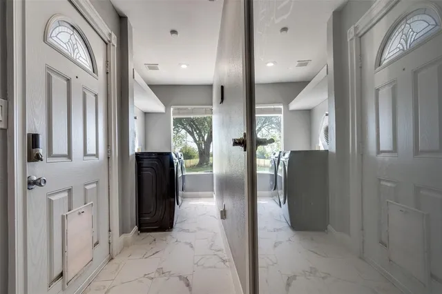 a view of a hallway with furniture and a glass door