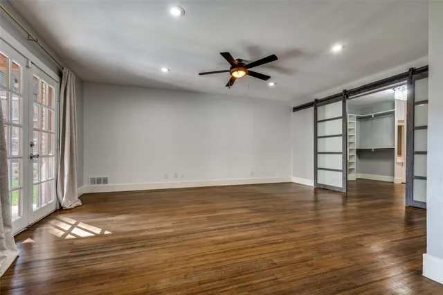 a view of empty room with wooden floor and window