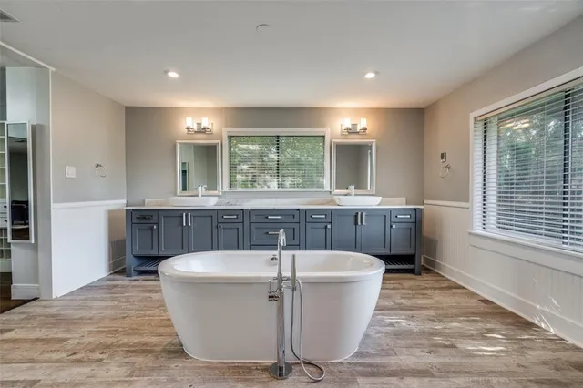 a spacious bathroom with a bathtub and a sink
