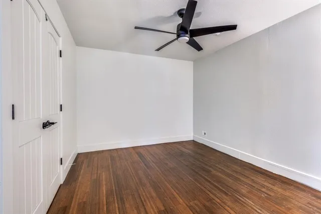 a view of a kitchen with kitchen island a sink wooden floor and black appliances