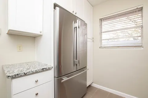 a view of a kitchen with a refrigerator and window