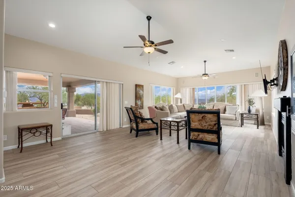 a living room with patio furniture and a floor to ceiling window