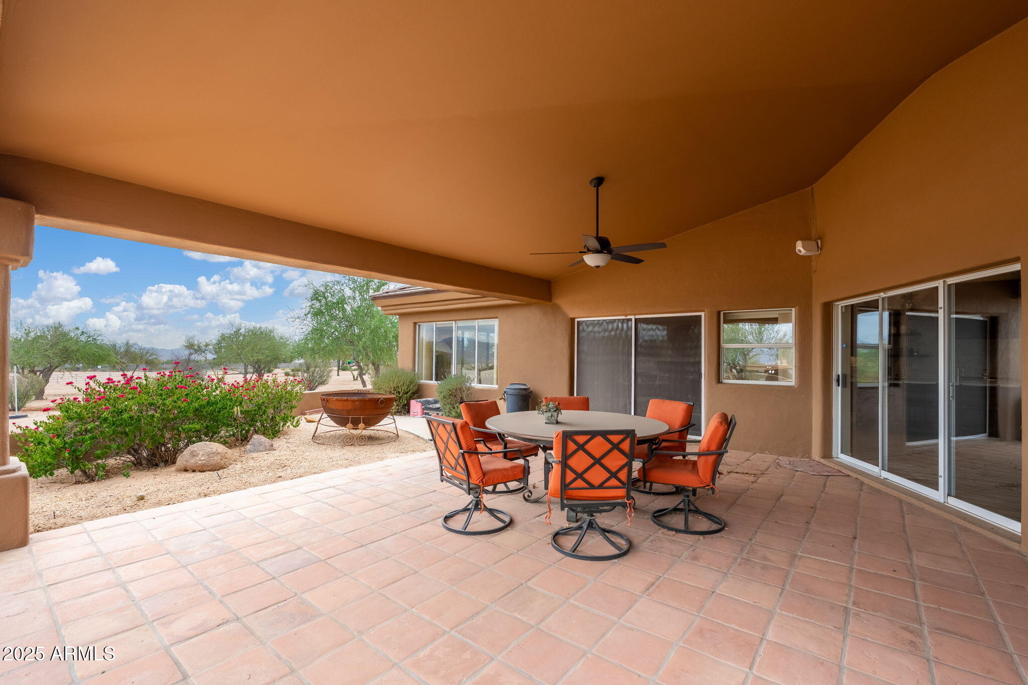 17047 East Dixileta Drive Rio Verde, AZ 85263 - Photo 66 of 115 a view of a patio with table and chairs and floor to ceiling window