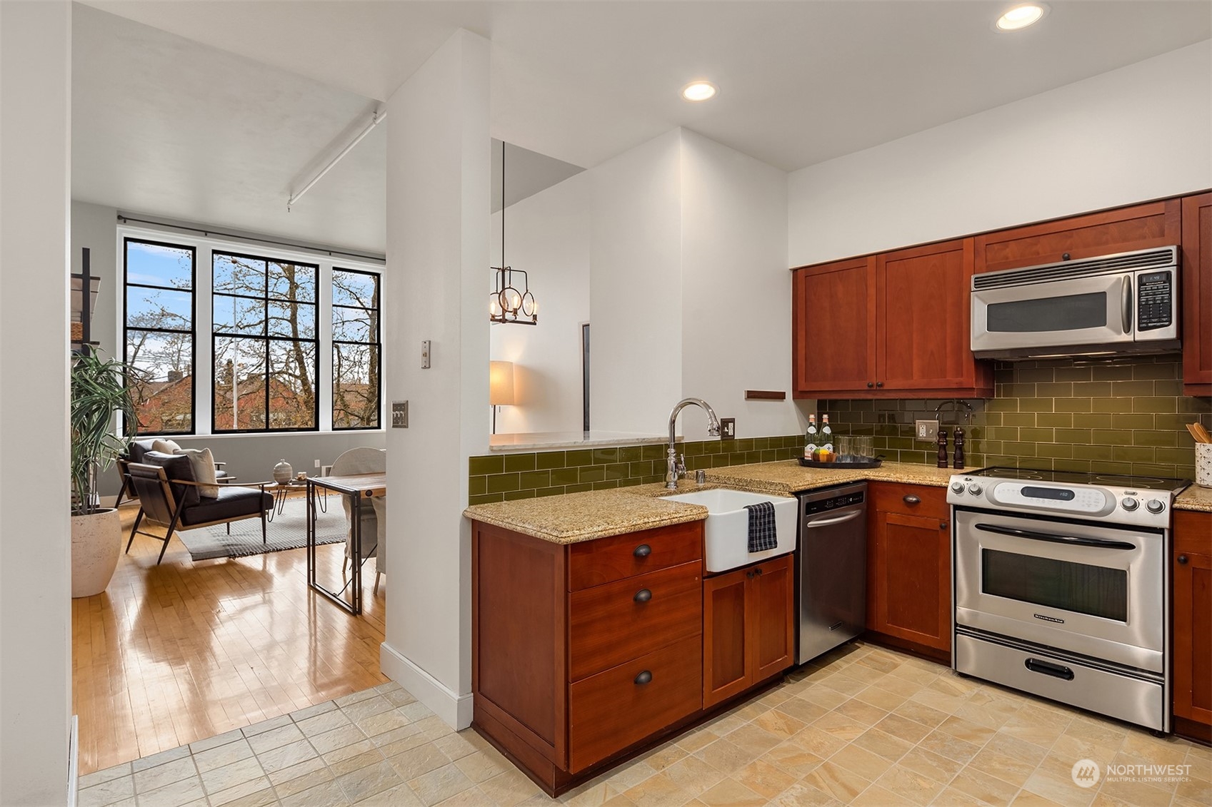 201 Galer Street, Unit 412 Seattle, WA 98109 - Photo 10 of 34 a kitchen with stainless steel appliances granite countertop a stove a sink and a microwave