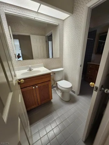a bathroom with a granite countertop toilet and a sink