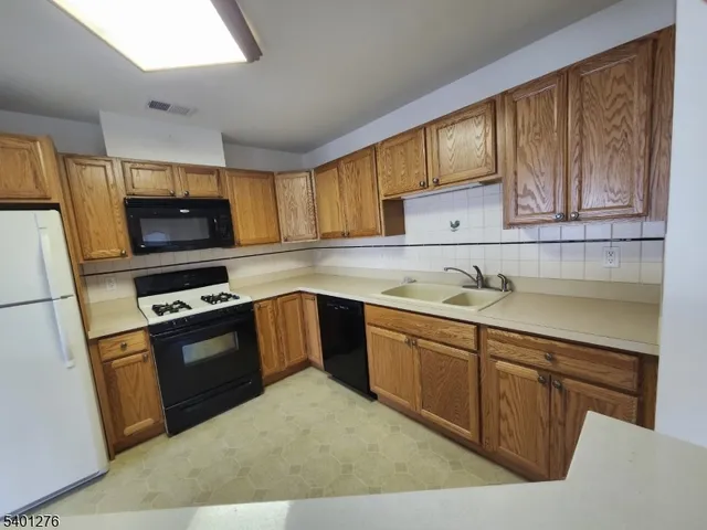 a kitchen with granite countertop a stove a sink and a microwave