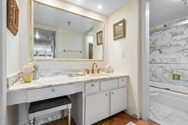 a spacious bathroom with a granite countertop sink and a mirror