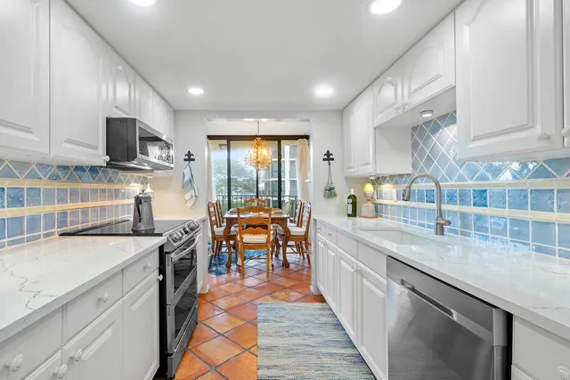 a kitchen with stainless steel appliances granite countertop sink stove top oven and cabinets