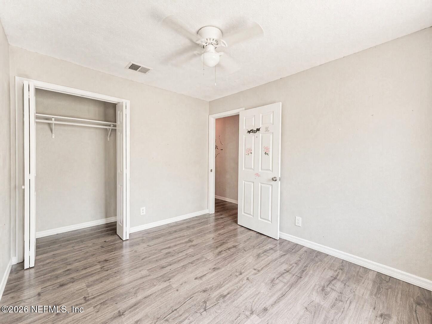 874 West 12th Street St. Augustine, FL 32084 - Photo 20 of 29 an empty room with wooden floor and a ceiling fan