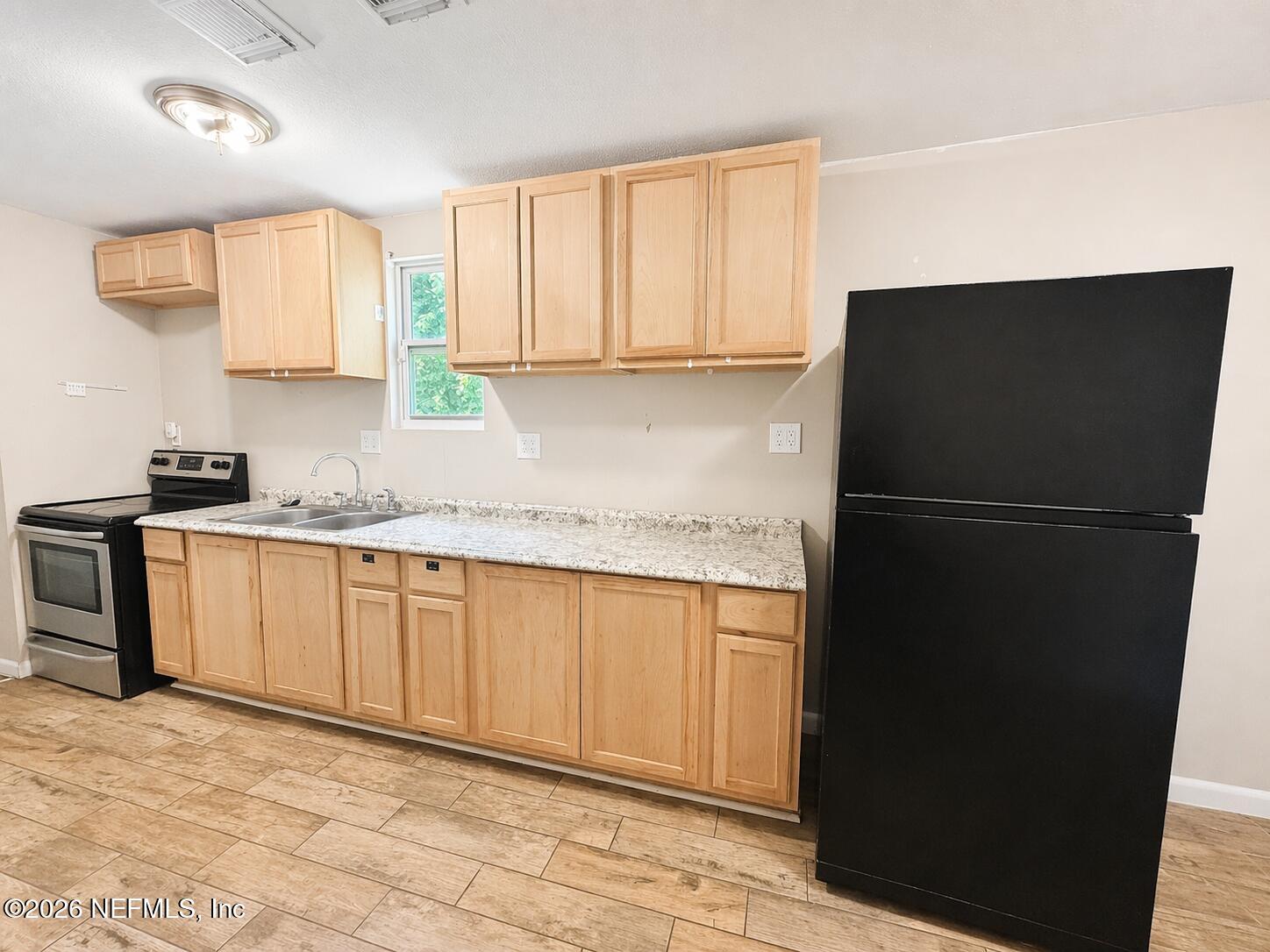 874 West 12th Street St. Augustine, FL 32084 - Photo 21 of 29 a kitchen with granite countertop cabinets and refrigerator