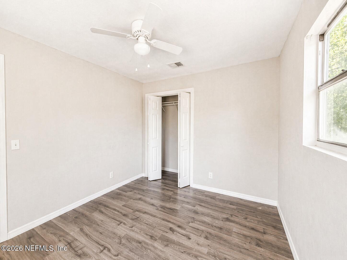 874 West 12th Street St. Augustine, FL 32084 - Photo 22 of 29 an empty room with wooden floor and windows