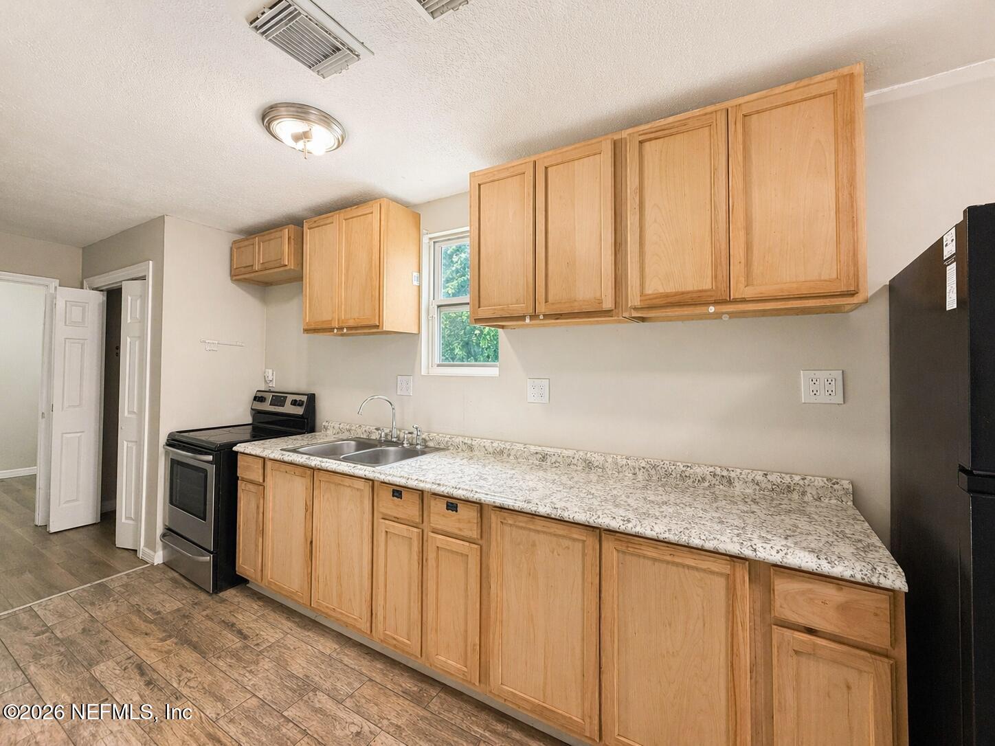 874 West 12th Street St. Augustine, FL 32084 - Photo 25 of 29 a kitchen with stainless steel appliances granite countertop a sink a stove and a refrigerator