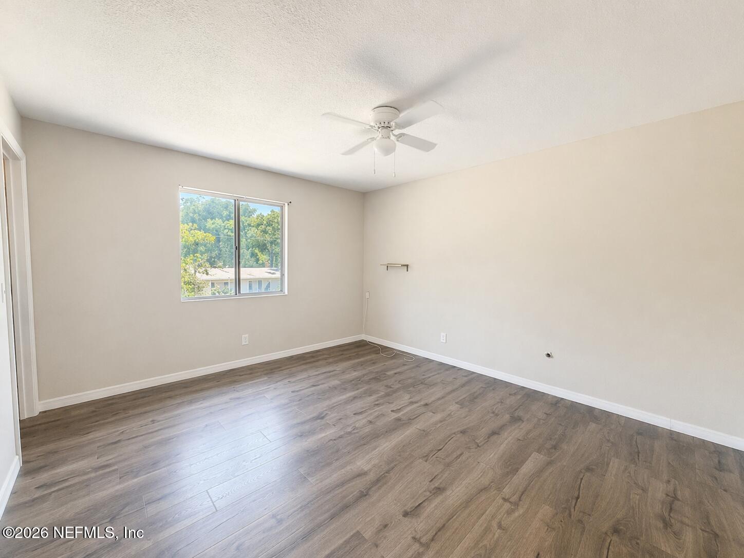 874 West 12th Street St. Augustine, FL 32084 - Photo 8 of 29 an empty room with wooden floor ceiling fan and windows