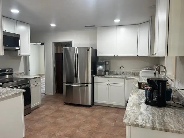 a kitchen with refrigerator and cabinets