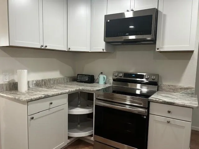 a kitchen with stainless steel appliances granite countertop a sink and a stove