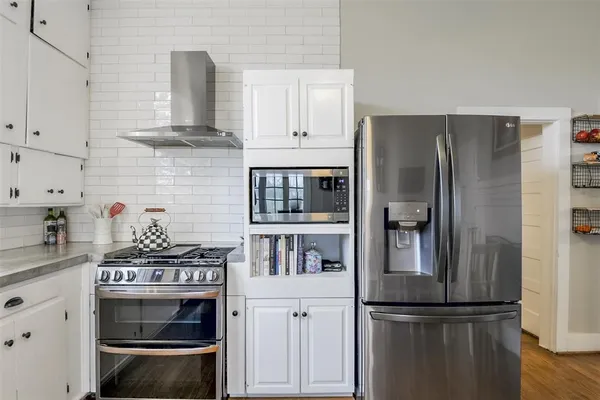 a kitchen with stainless steel appliances granite countertop a refrigerator a stove and a sink