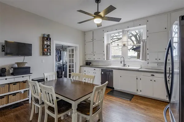a kitchen with a table chairs sink and cabinets