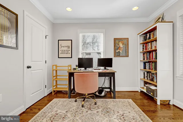 a view of a workspace with furniture and a window