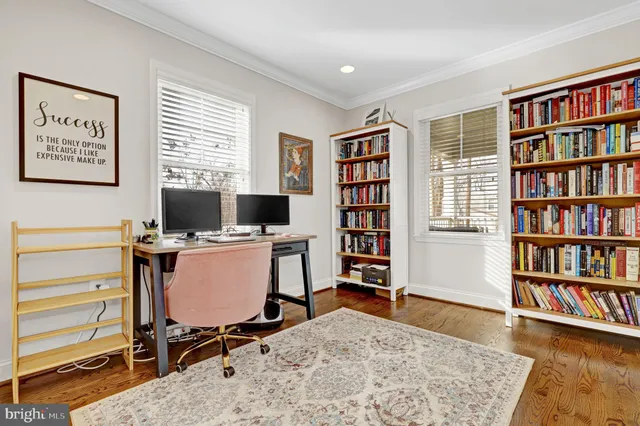 a view of a workspace with furniture and a bookshelf