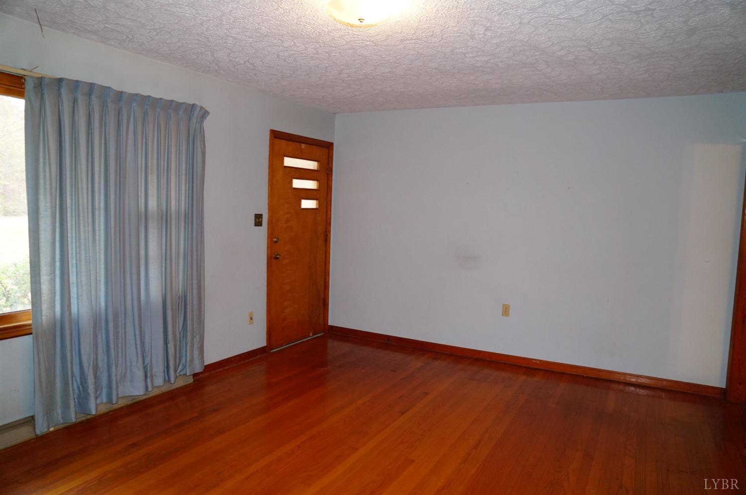 2106 Railview Road Gladys, VA 24554 - Photo 4 of 20 an empty room with wooden floor and windows