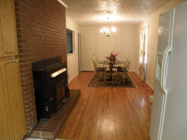 373 Greene Settlement Road Gray, GA 31032 - Photo 23 of 34 a dining room with a wooden floor and a fireplace