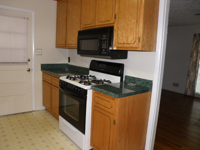 373 Greene Settlement Road Gray, GA 31032 - Photo 34 of 34 a kitchen with granite countertop a stove top oven microwave and cabinets