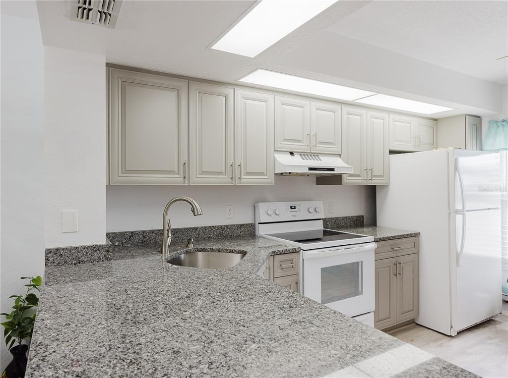26282 Rampart Boulevard, Unit 204 Punta Gorda, FL 33983 - Photo 10 of 34 a kitchen with stainless steel appliances granite countertop a sink stove and refrigerator
