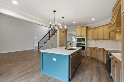 a kitchen with granite countertop a sink cabinets and wooden floor