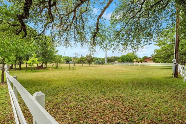 a yellow house with a yard and a large tree