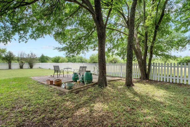 a view of a yard with a house and large trees