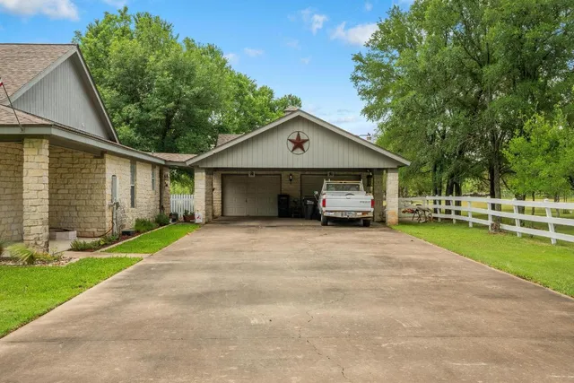 a front view of a house with a yard and trees