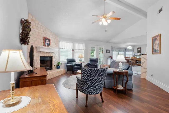 a living room with furniture a fireplace and a chandelier