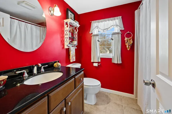 a bathroom with a toilet a sink and mirror