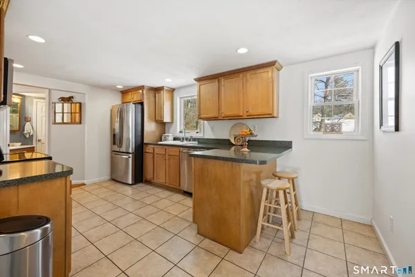 a kitchen with stainless steel appliances granite countertop a refrigerator stove top oven and sink