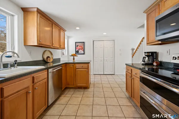 a kitchen with stainless steel appliances granite countertop a refrigerator and a stove top oven