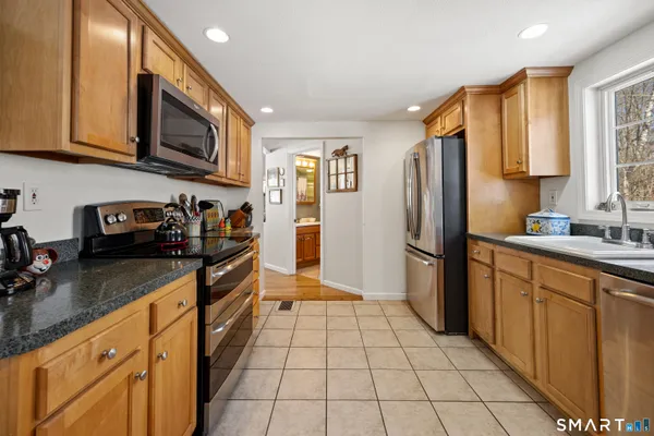 a kitchen with stainless steel appliances granite countertop a refrigerator stove top oven and sink