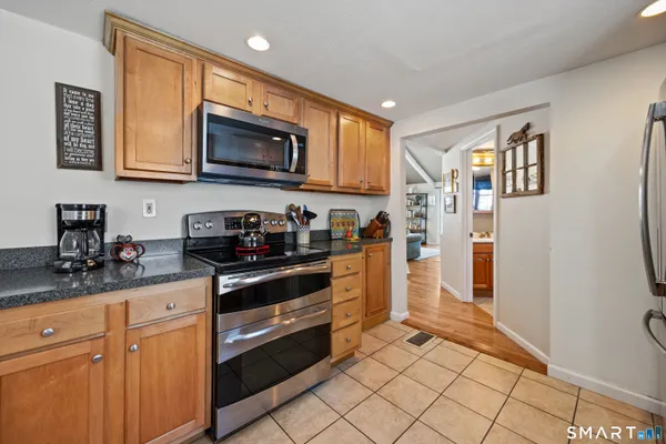 a kitchen with stainless steel appliances granite countertop a refrigerator and a stove top oven