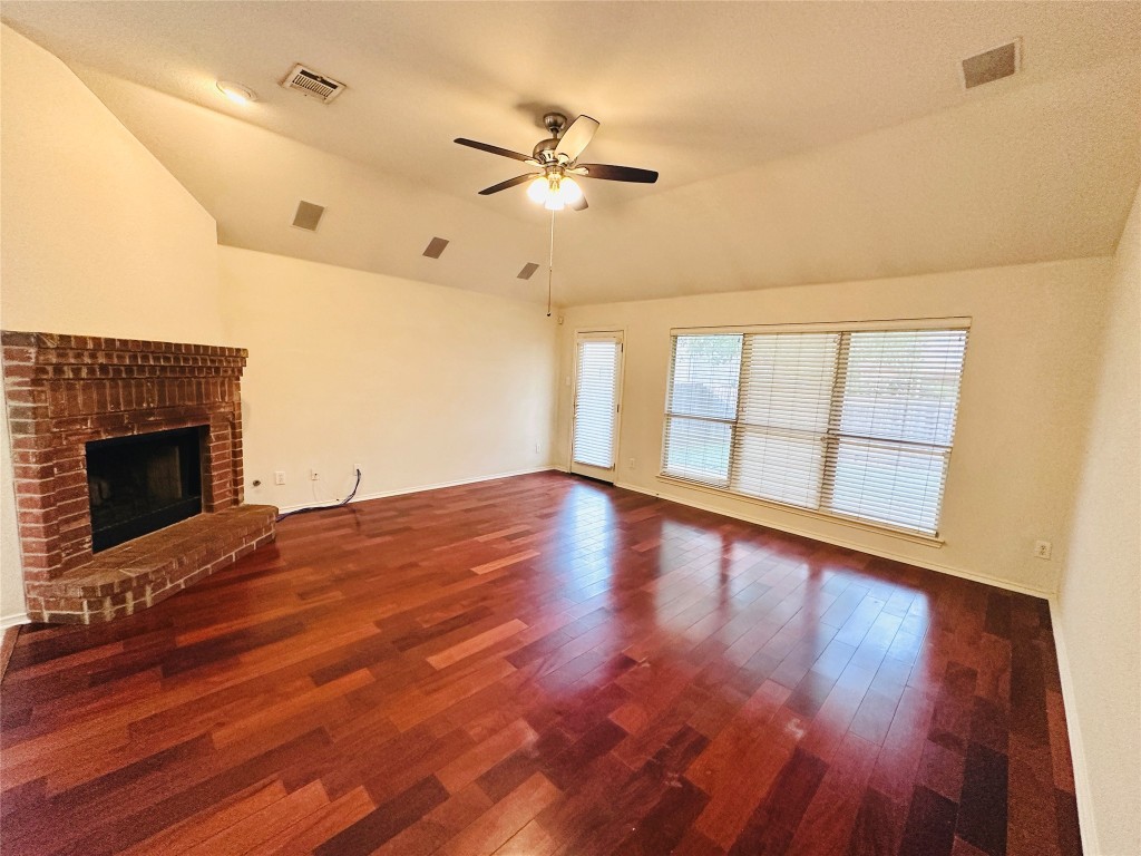 1101 Hunter's Creek Drive Cedar Park, TX 78613 - Photo 13 of 37 a view of an empty room with wooden floor fireplace and a window