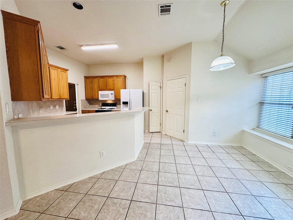 1101 Hunter's Creek Drive Cedar Park, TX 78613 - Photo 16 of 37 a kitchen with granite countertop a stove a sink and a refrigerator