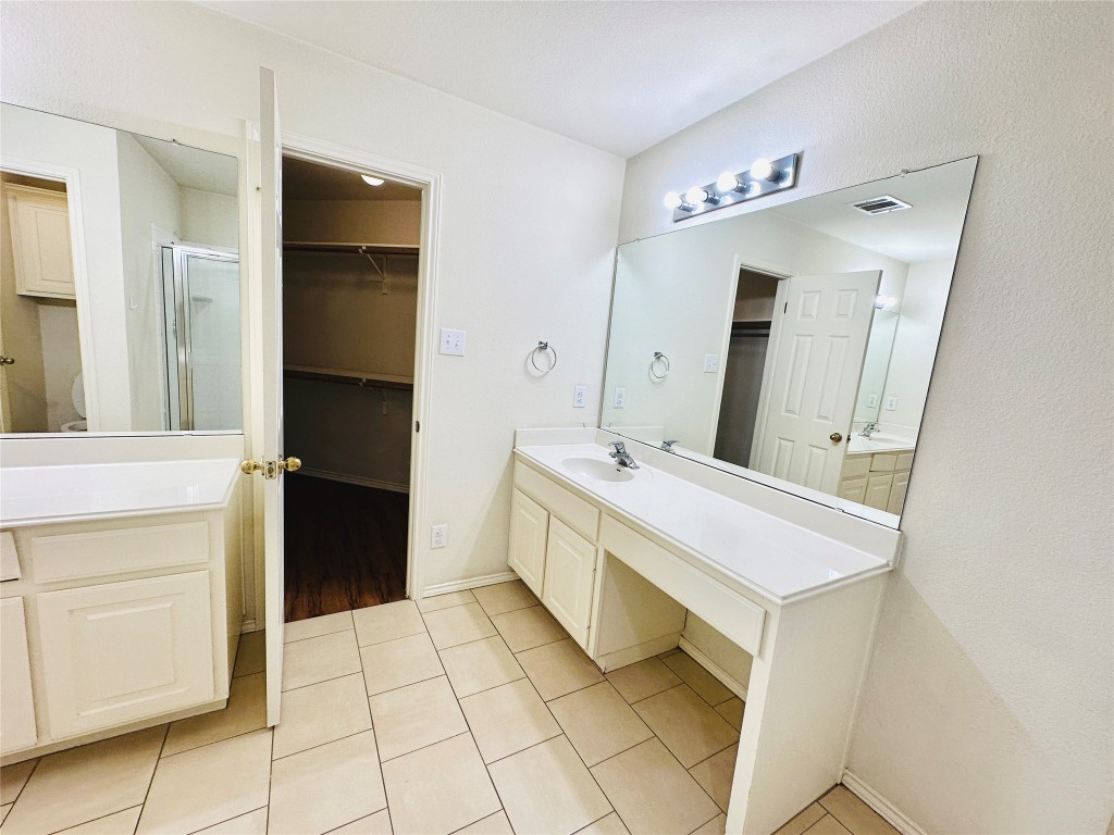 1101 Hunter's Creek Drive Cedar Park, TX 78613 - Photo 36 of 37 Bathroom with vanity, a spacious closet, a stall shower, and light tile patterned floors