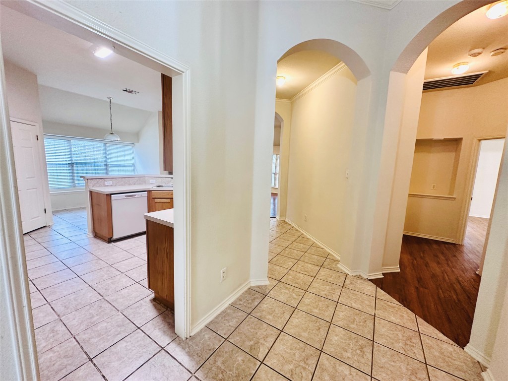 1101 Hunter's Creek Drive Cedar Park, TX 78613 - Photo 4 of 37 Corridor featuring light tile patterned floors, arched walkways, and crown molding