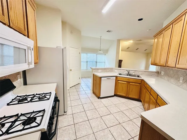 a kitchen with a sink a refrigerator and cabinets