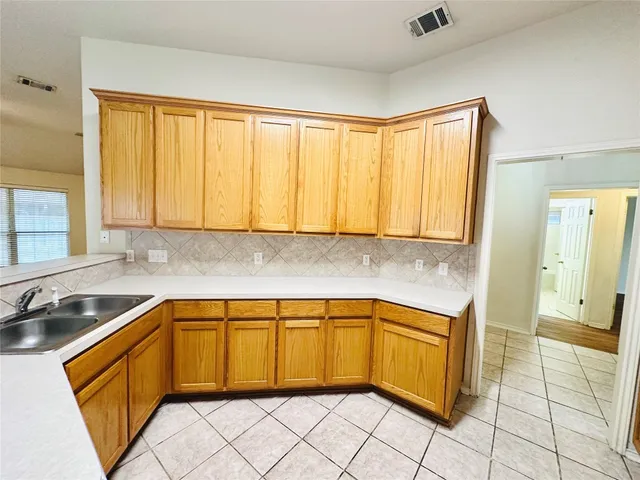 a view of an empty room with wooden floor fireplace and a window