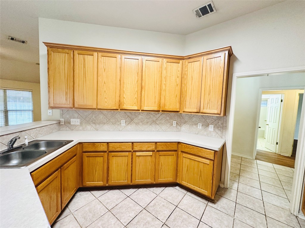 1101 Hunter's Creek Drive Cedar Park, TX 78613 - Photo 7 of 37 Kitchen with light countertops, tasteful backsplash, and light tile patterned floors