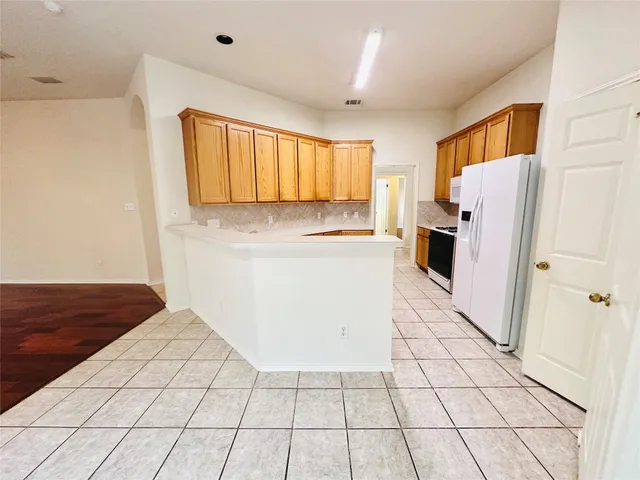 a kitchen with granite countertop a stove a sink and a refrigerator