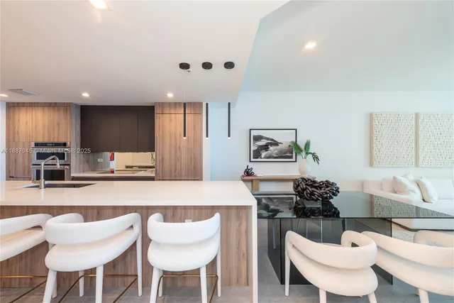 a kitchen with a dining table chairs and white cabinets