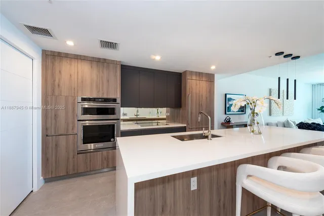 a kitchen with kitchen island a stove a sink and a refrigerator