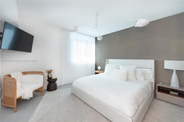 a bedroom with bed and flat screen tv