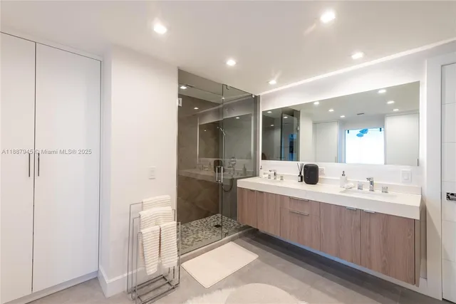 a large bathroom with a double vanity sink a mirror and a shower