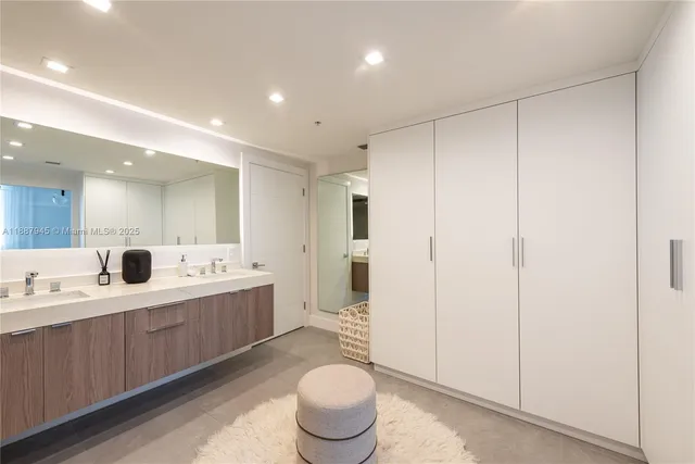 a large bathroom with a double vanity sink toilet and a mirror